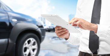 Business Professional Analyzes Dealership Data on Ipad